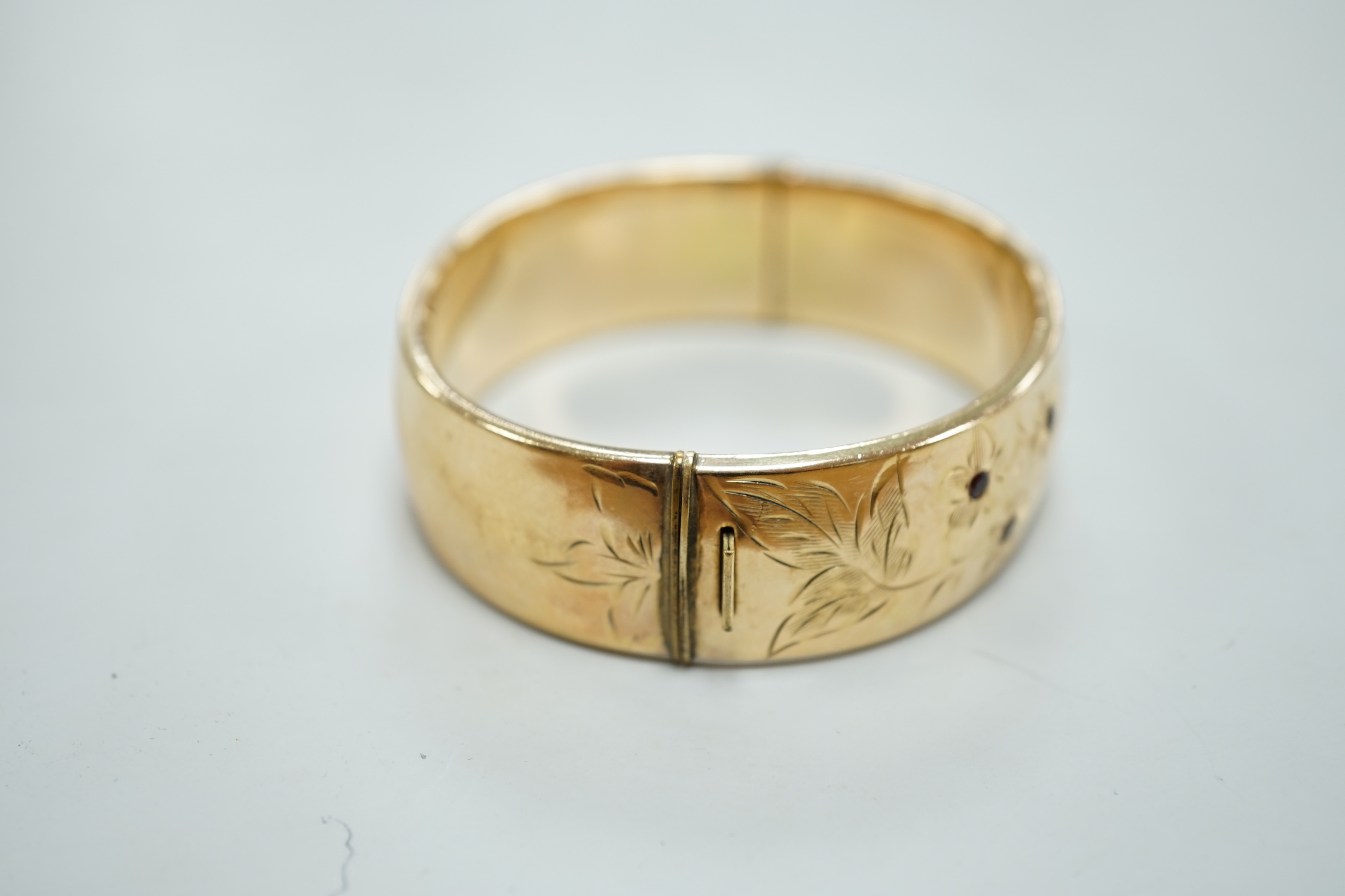 A 1960's 9ct gold hinged bangle, by Smith & Pepper, 30.4 grams and a rolled gold bangle.
